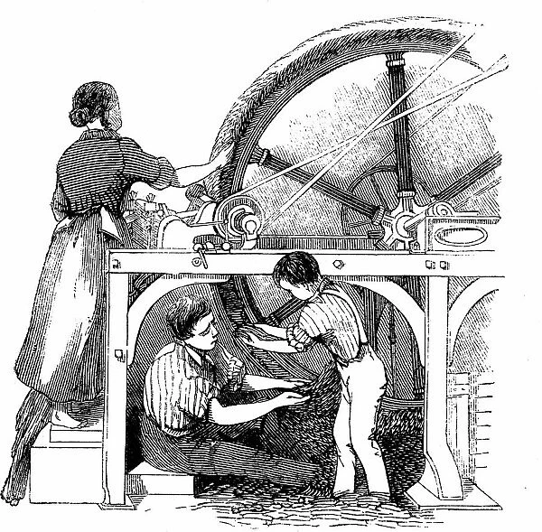 Man, woman & small boy working wheel for combing long staple wool into slivers for
