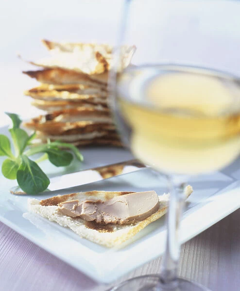 Melba toasted bread with Foie gras pate and a glass of white wine