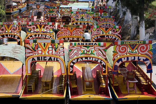 Mexico, Mexico City, Xochimilco, colourful trajinera boats moored in canal