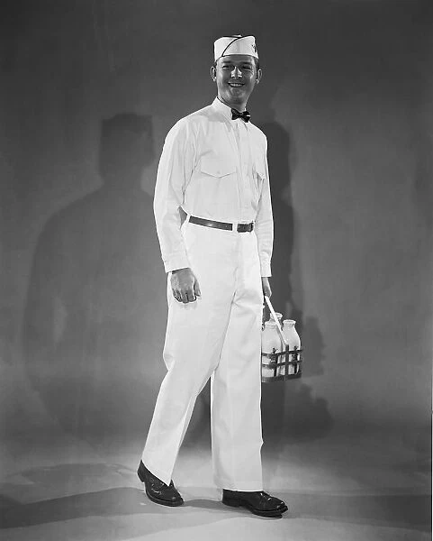 Milkman in uniform carrying a crate of milk