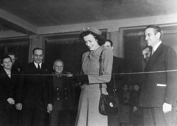 Miss harriman cutting the ribbon at the opening of the prefabricated housing in the usa exhibition at the moscow architects club, 1940s, on the right is us ambassador william averell harriman