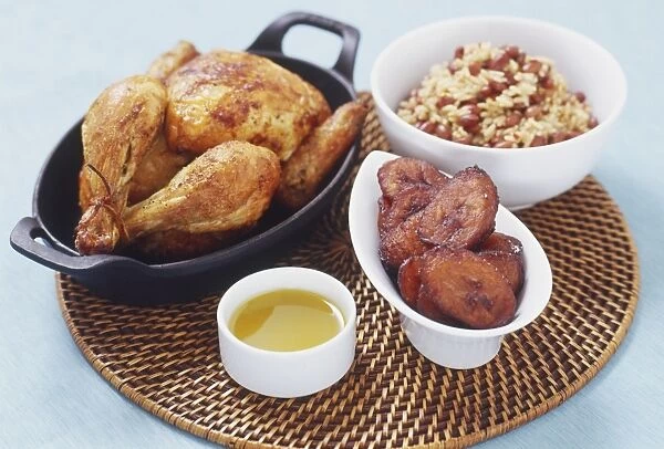 Mojo-marinated chicken served with bowls of red beans and rice (congri), caramelized plantains and sour orange mojo