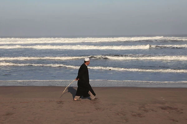 Morrocan man walking on a beach near Azemmour