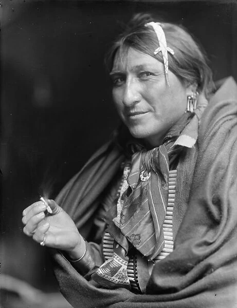 Native North American Indian smoking cigarette. Photograph by Edward Curtis (1868-1952)