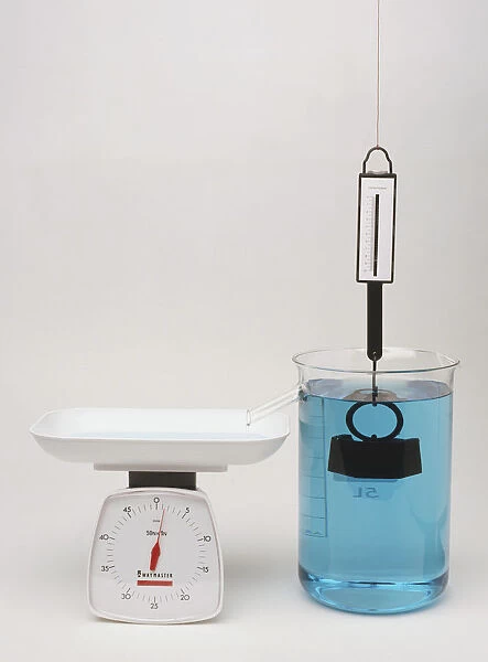 Newton meter pulled by weight immersed in water with scales showing upthrust