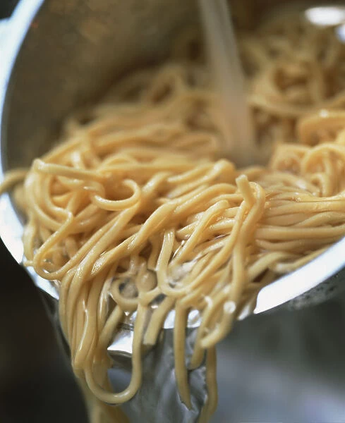 Noodles being drained in a colander