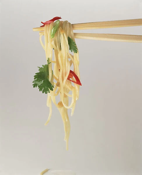 Noodles hanging from chopsticks