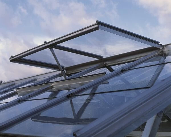 Open hinged vent on roof of domestic greenhouse