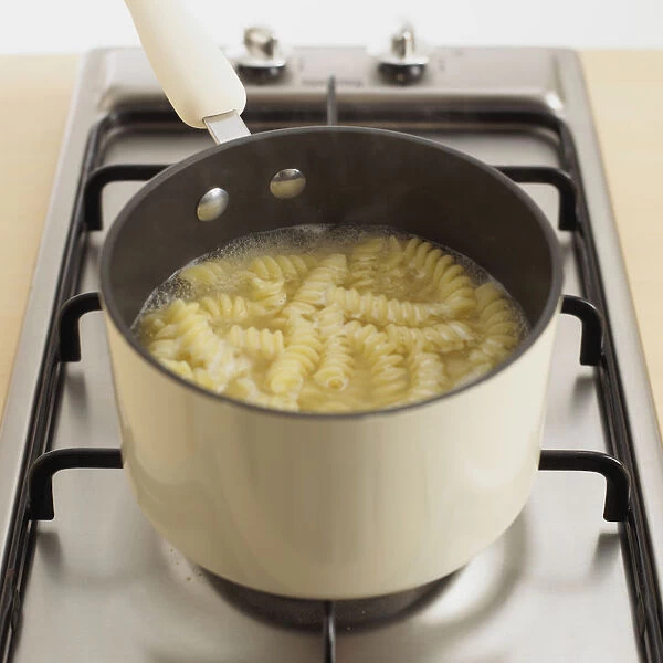 Pan of fusilli pasta boiling, close-up