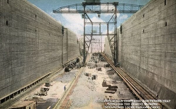 Panama Canal Under Construction. ca. 1913, Miraflores, Panama, CONCRETE WALLS COMPLETED AND CRANES THAT OPERATED THE CEMENT BUCKETS, MIRAFLORES LOCKS, PANAMA CANAL. The side walls are 50 feet wide at the surface of the floor, perpendicular on the face. The walls are 25 feet thick at the base and narrowing towards the top where they are 8 feet thick. The amount of concrete required being over 800, 000 cubic feet, the concrete is brought from the mixers in buckets on a narrow gage line, and deposited by means of cranes