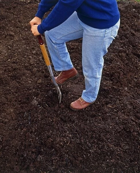 Person digging soil with fork