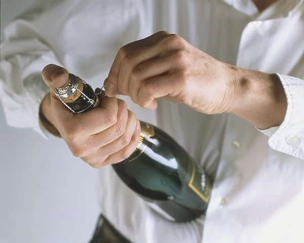 Person opening champagne bottle