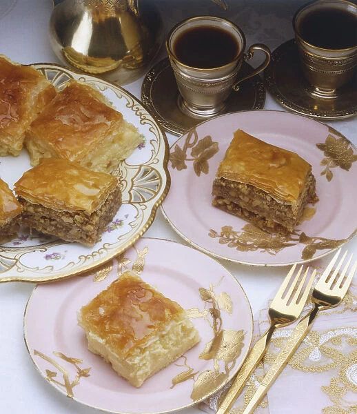 Pieces of layered apple cake served on plates, coffee served in silver cups