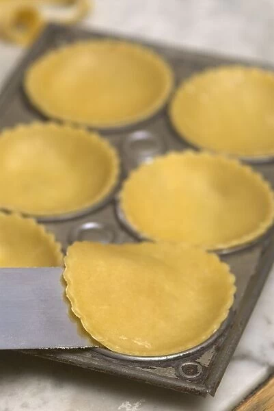 Placing pastry discs into the individual bases