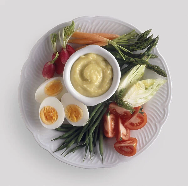 Plate of crudites, boiled eggs and a bowl of Aioli sauce, view from above