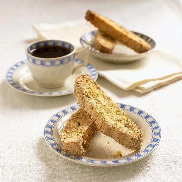 Plates of biscotti, cup of coffee, napkins