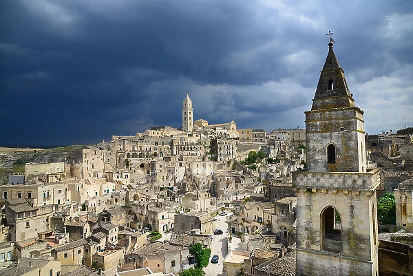 Pontifical Basilica Cathedral of Maria Santissima della Bruna and Sant'Eustachio dominates the view over Matera. In the foreground, the bell tower of the Church of San Pietro Barisano, Matera, Basilicata, Italy, Europe