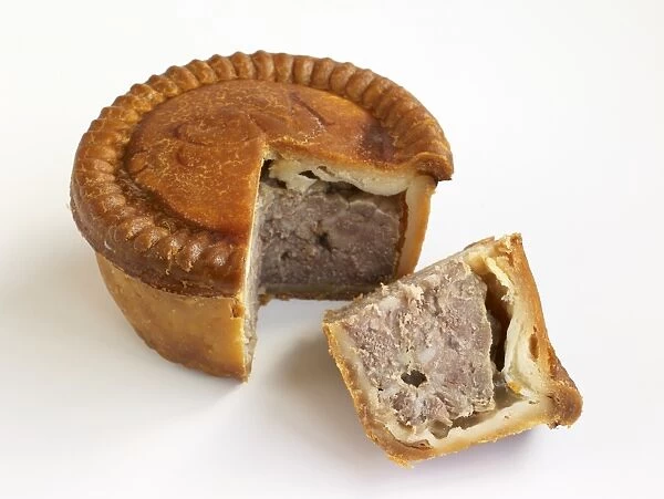 Pork pie with pastry crust, and slice showing meat inside, close-up