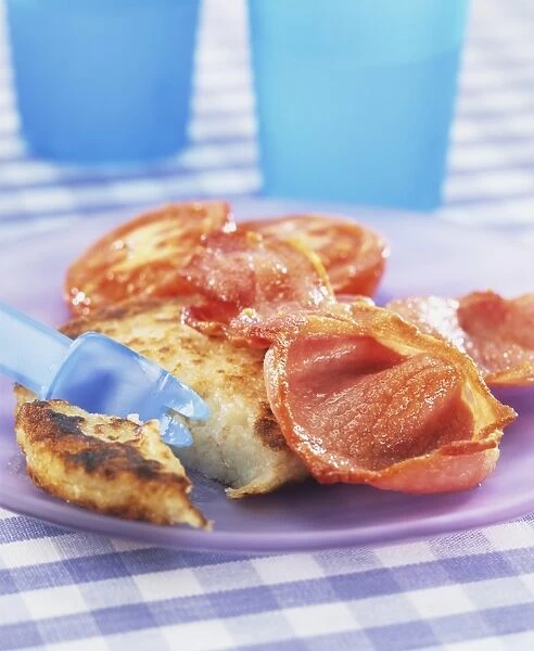 Potato cakes served with grilled bacon on plastic plate, close up
