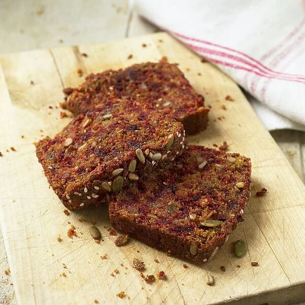 Pumpkin seed and berry bread slices on chopping board