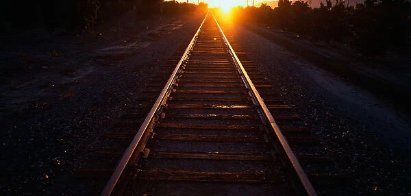These are railroad tracks that go off into infinity at sunrise. The sun is at the end of the tracks at the horizon