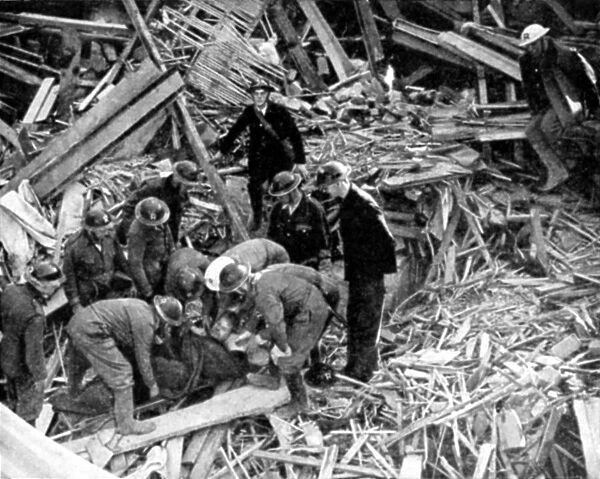 Rescue workers releasing injured person from the debris of a building destroyed by German bombing