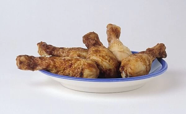 Five roast chicken legs on blue plate