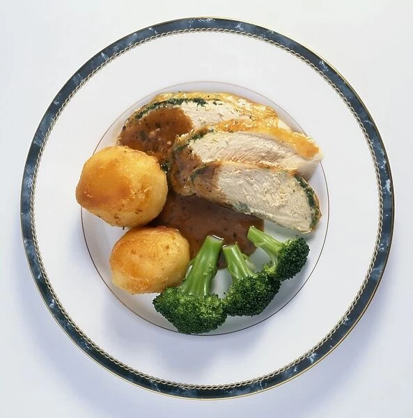 Roasted chicken breast with roast potatoes, broccoli and gravy