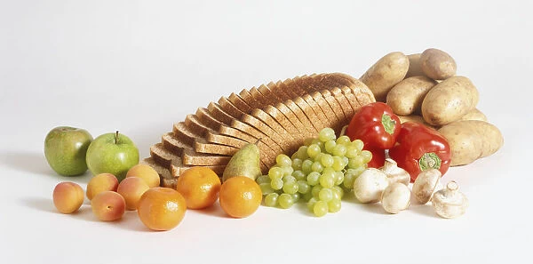 Selection of high-fibre foods, including slices of wholemeal bread, potatoes, red peppers, mushrooms, green grapes, pears, peaches and apples