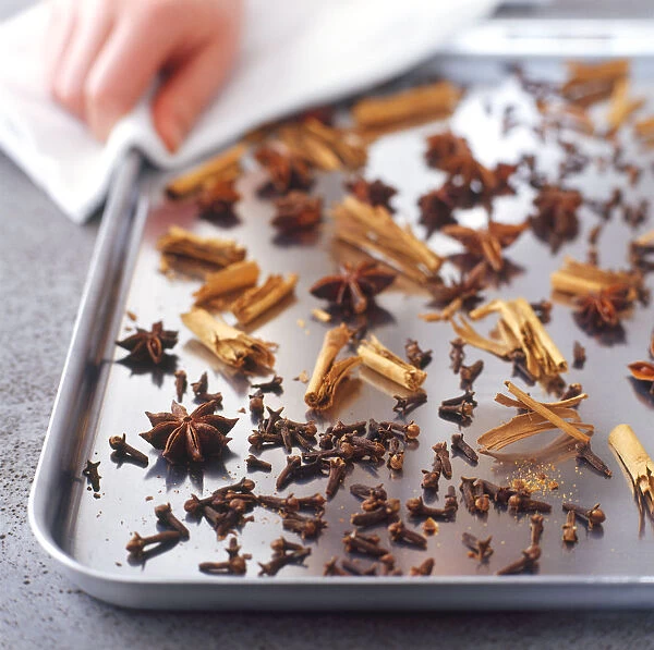 Selection of spices, including star anise, cinnamon and cloves, on a baking tray
