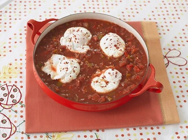 Shakshouka, eggs poached in tomato and pepper sauce, in a pan