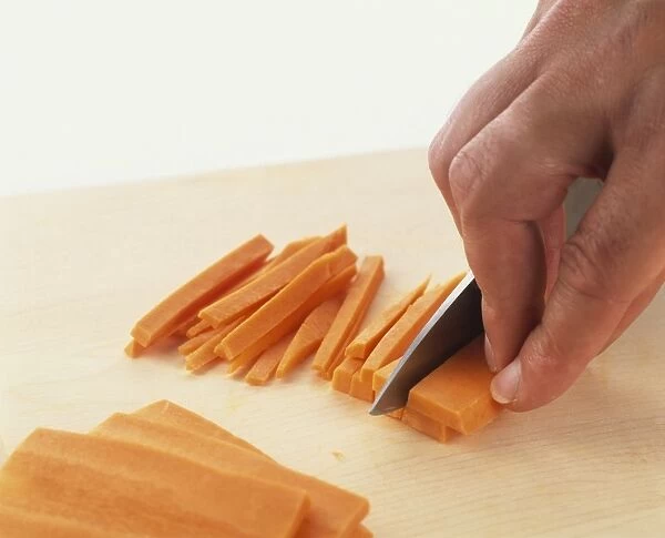 Slicing carrots into thin strips, close-up