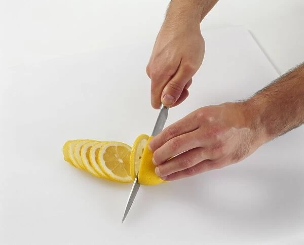 Slicing a lemon with a chefs knife, close-up