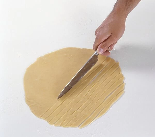 Slicing rolled out pastry dough into thin strips to make a lattice, close-up