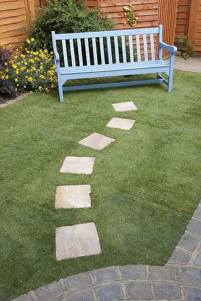 Small garden with stepping stones leading to a bench