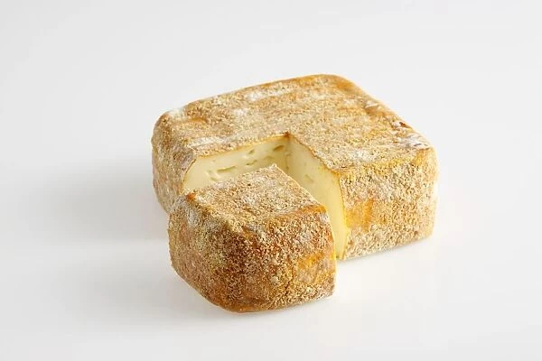 Square and slice of French Sable de Wissant cows milk cheese with breadcrumbs on rind