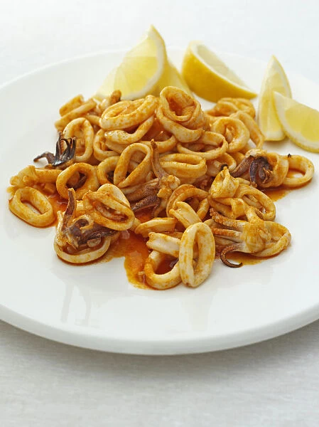 Squid with lemon slices on plate
