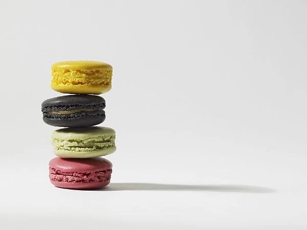 Stack of four yellow, brown, green and pink macaroons