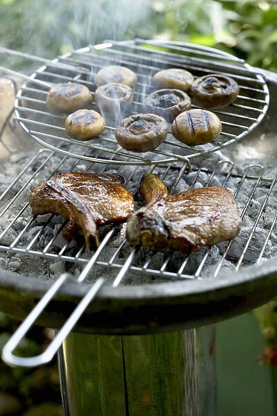 Steaks and mushrooms on barbecue