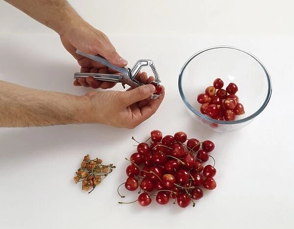 Stoning cherries with a pitter, close-up