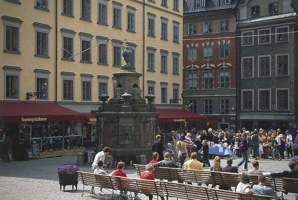 Sweden, Stockholm, people seated in Stortorget, a square in the heart of the city between the bridges, with a well dating from 1778. It was the scene of the Stockholm Bloodbath in 1520