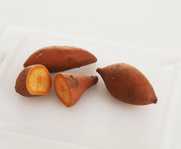 Three sweet potatoes, one of them cut in half