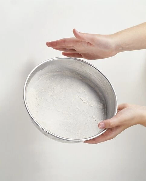 Tapping cake tin to spread flour evenly