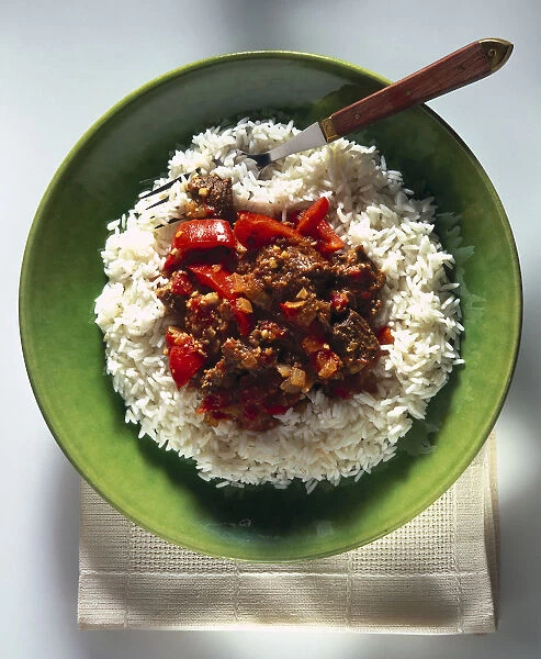 Thai Red Beef Curry, cubes of chuck steak served on dinner plate on bed of boiled white rice