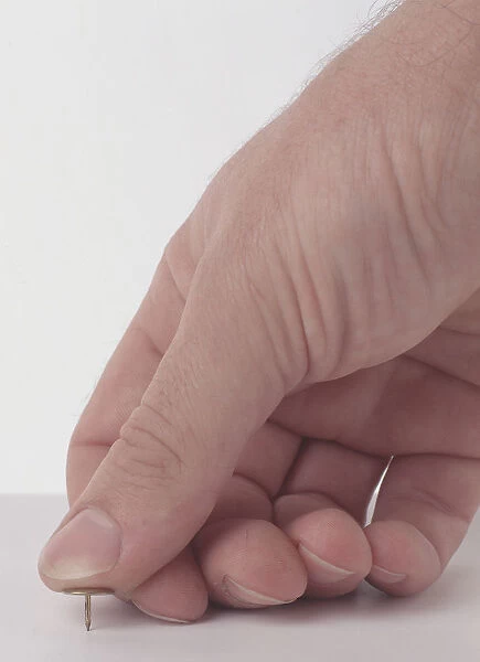 Thumb pushing drawing pin illustrating pressure over a small pin point