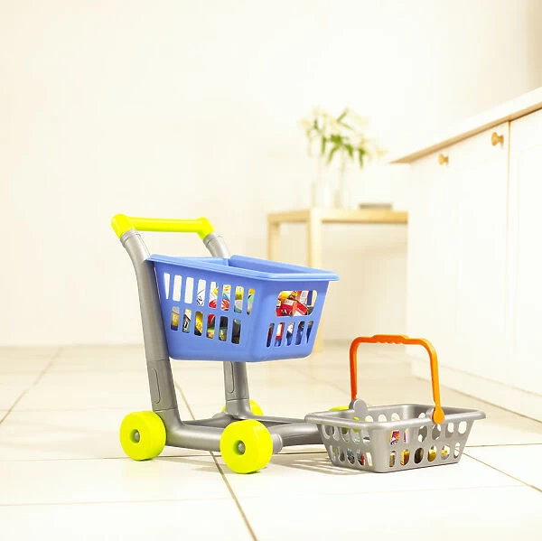 Toy supermarket trolley and basket on kitchen floor
