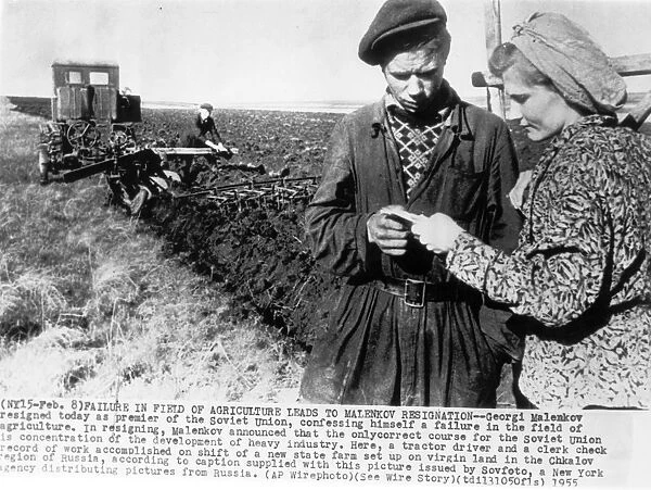 A tractor driver and clerk checking the record of work accomplished on a shift of a new state farm set up on virgin land in the chkalov region of russia, 1955