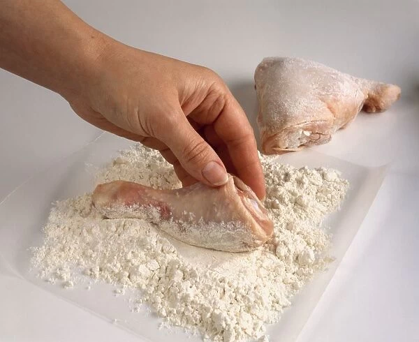 Using hands to cover chicken pieces in flour