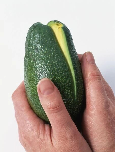 Using hands to separate sliced avocado