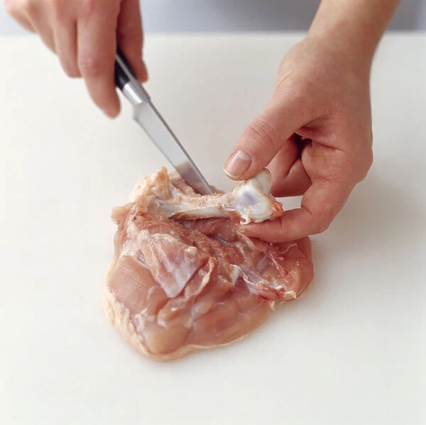 Using kitchen knife to remove bone from chicken thigh